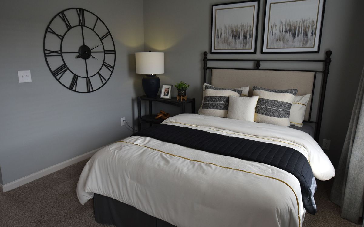 Bedroom with two large framed wall art pieces hanging securely above the headboard