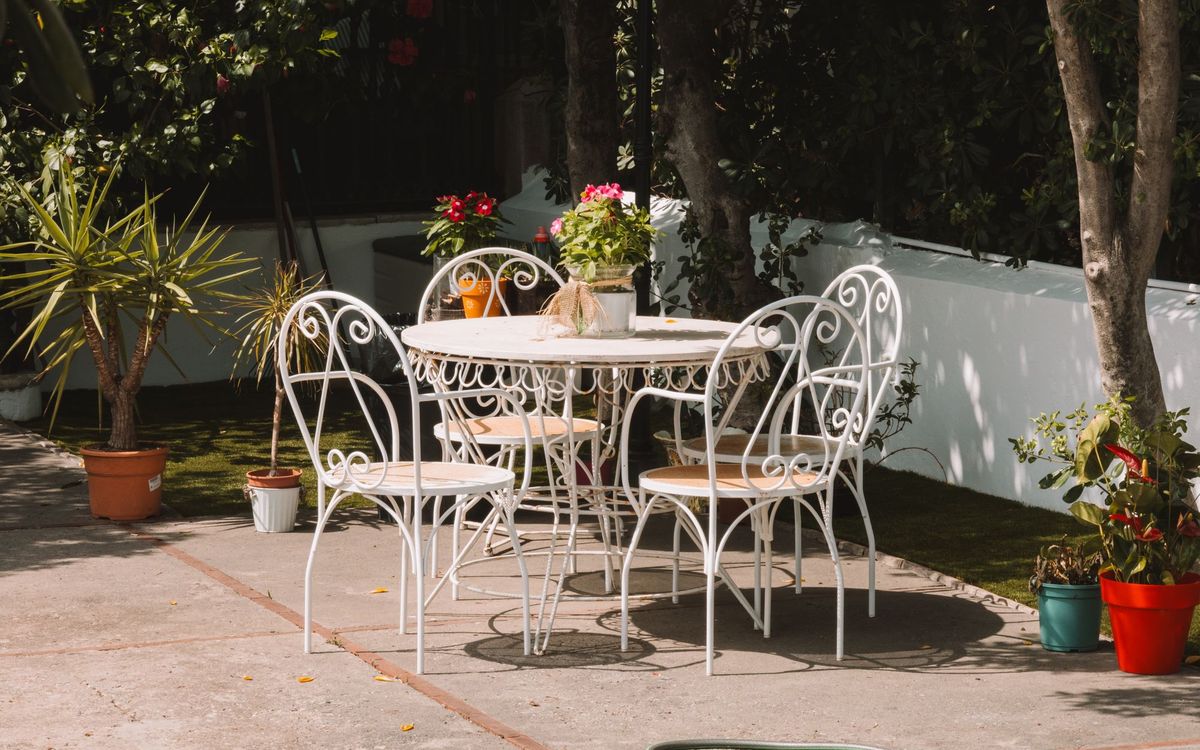 White wrought iron table and chairs on a sunny garden patio