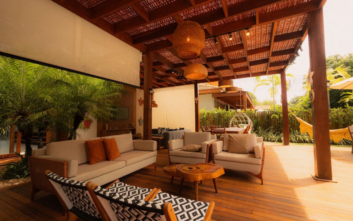 Cushioned outdoor sofa and armchairs on a covered wooden patio deck
