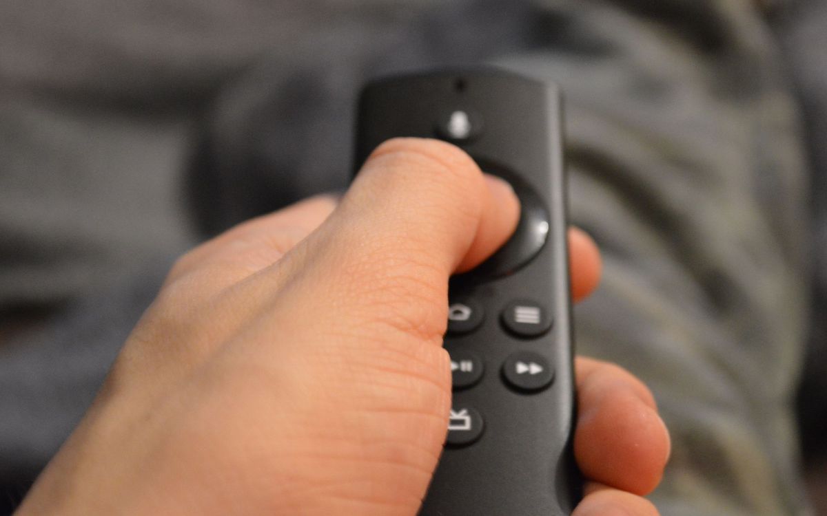 Hand holding a black TV remote control